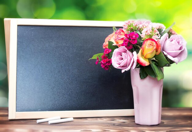 Foto bloemen in vaas en krijtbord lege kopie ruimte achtergrond