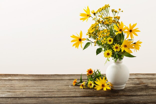 Bloemen in vaas op houten tafel