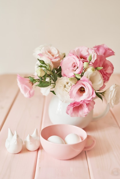 bloemen met eieren voor Pasen op roze houten