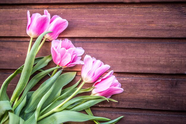 Bloemen. Roze tulpen op een houten achtergrond met ruimte voor tekst, vintage kleurstijl