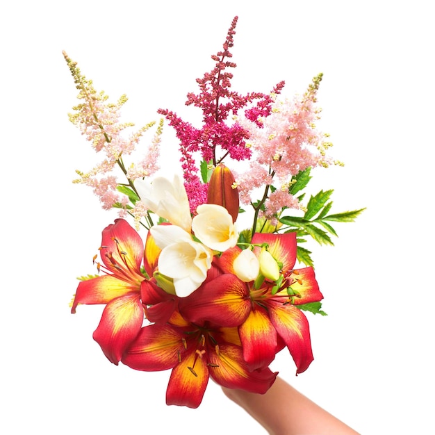 Bloemen van lelie, ixia en astilbe in een boeket in de hand houden geïsoleerd op een witte achtergrond. Platliggend, bovenaanzicht