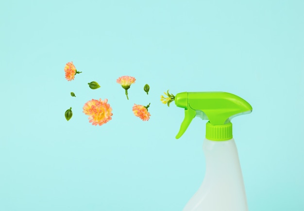 Bloemen vliegen uit een plastic spuitfles op een lichte achtergrond