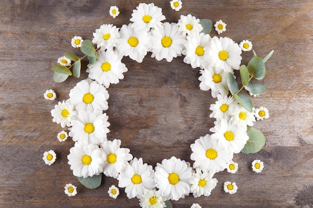 Bloemenkroonkader op houten achtergrond