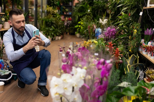 Bloemenwinkelmanager filmt een potplant op een smartphone