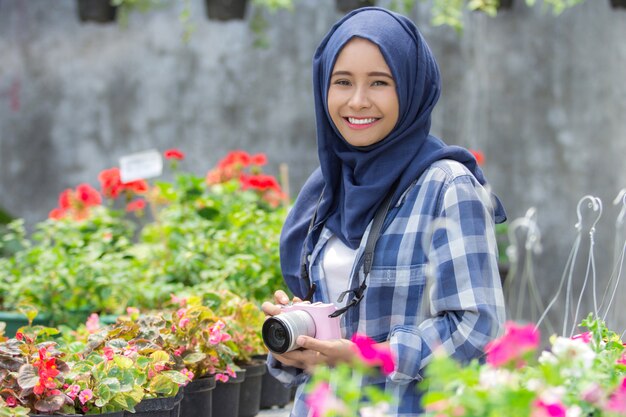 Bloemist die met camera glimlacht