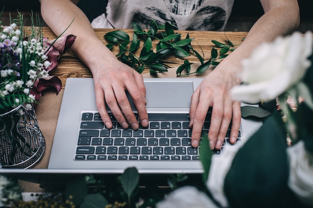 Bloemist die met laptop werkt