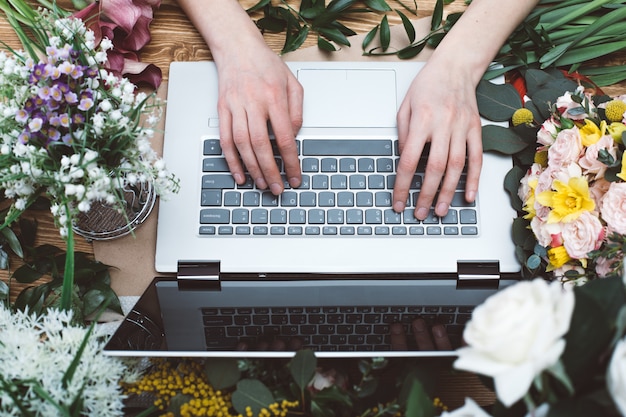 Bloemist die met laptop werkt