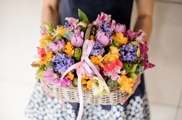 Bloemist die mooie rieten mand met bloemen houdt