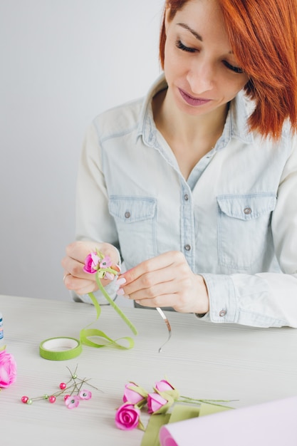 Foto bloemist doet een krans met kunstbloemen van foamiran