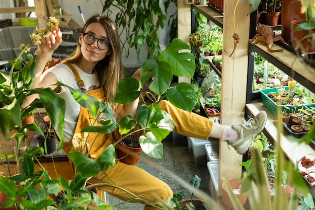 Bloemist geniet van plantenverzorging in kas of bloemenwinkel