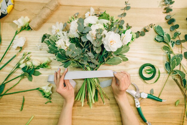 Bloemist handen snijdt bloemsamenstelling met snoeischaar