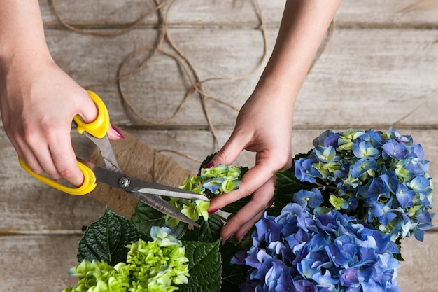 Bloemist maakt een boeket kasbloemen. de decorateur werkt in een kas met een paars boeket. floristiek workshop, vaardigheid, decor, klein bedrijfsconcept