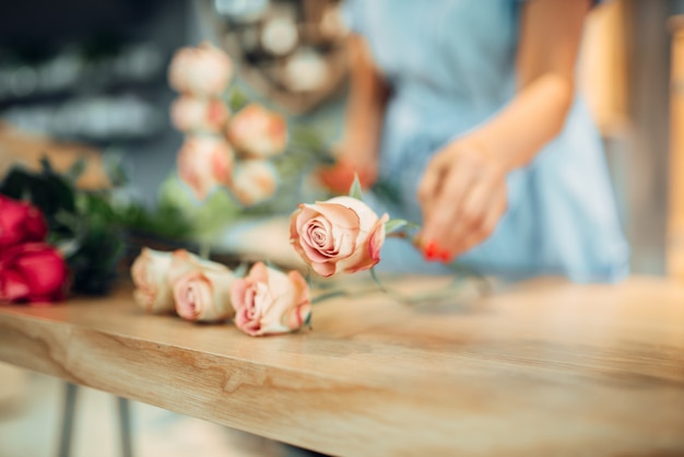 Bloemist maakt roos compositie in bloemenwinkel