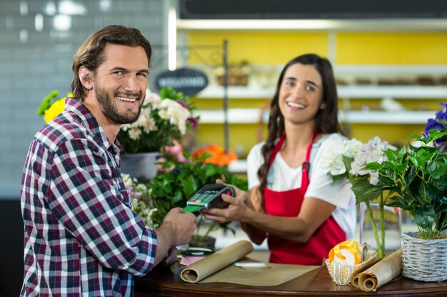 Bloemist ontvangt een betaling per creditcard van de klant in de bloemenwinkel