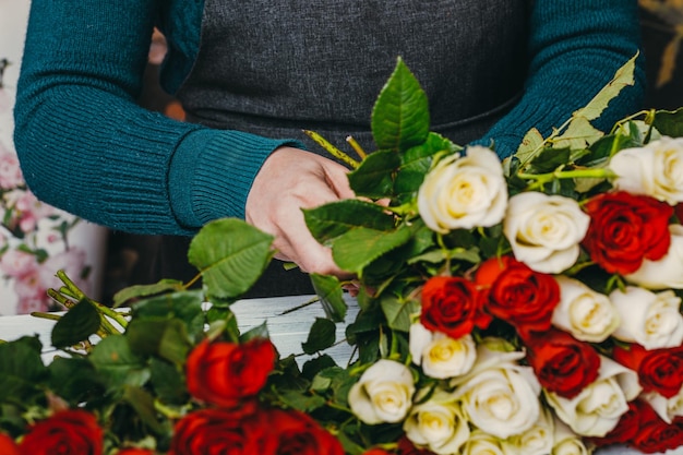 Bloemist op het werk maakt een modieus modern boeket van verschillende bloemen