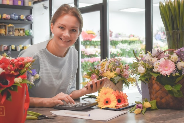Bloemist verzamelt bloemenboeket Werken in een bloemenwinkel Bloemisterij voor kleine bedrijven