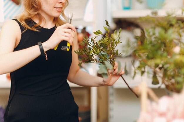 Bloemist vrouw maakt boeket in bloemenboetiek.