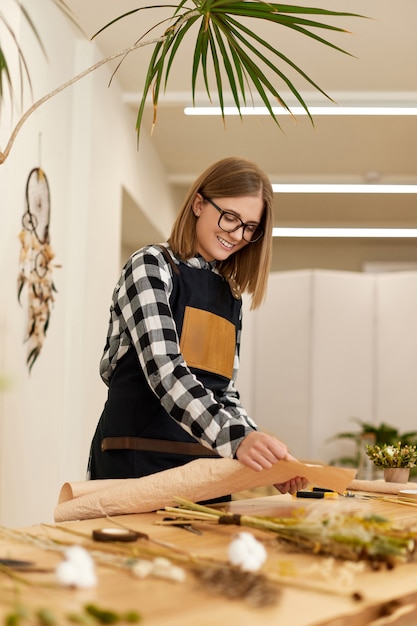 Bloemist vrouw maakt mooi boeket gedroogde bloemen op houten tafel