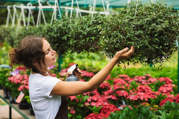 Bloemist vrouw werkt in kas over planten