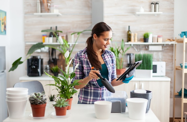 Bloemist zaait nieuwe bloemen in de keuken van het huis tijdens het tuinieren