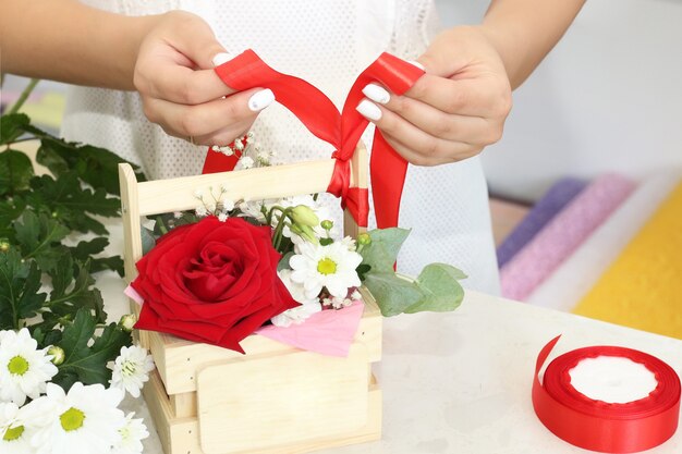 Bloemistenmeisje dat in een bloemenwinkel werkt zachte tinten verse lentebloemen verpakt in decoratief papier of in een doos geplaatst bloemistenzaak