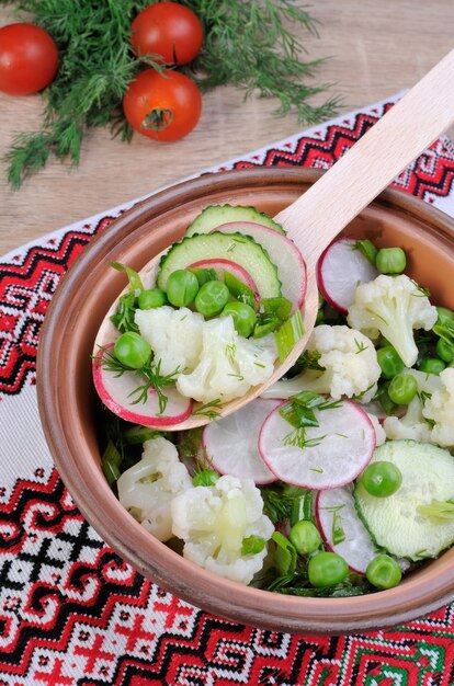 Bloemkoolsalade met komkommer, radijs, doperwten en uien