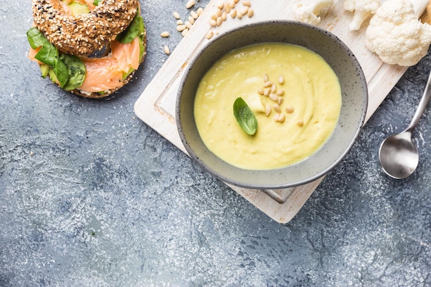 Bloemkoolsoeppuree op een stenen ondergrond, bovenaanzicht. Vegetarisch gezond voedselconcept