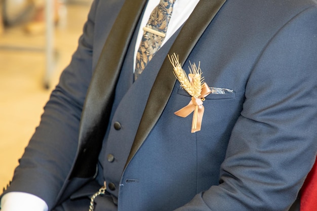 Bloemman ooren van tarwe boutonniere in de bruidegom pak tijdens elegantie bruiloft viering