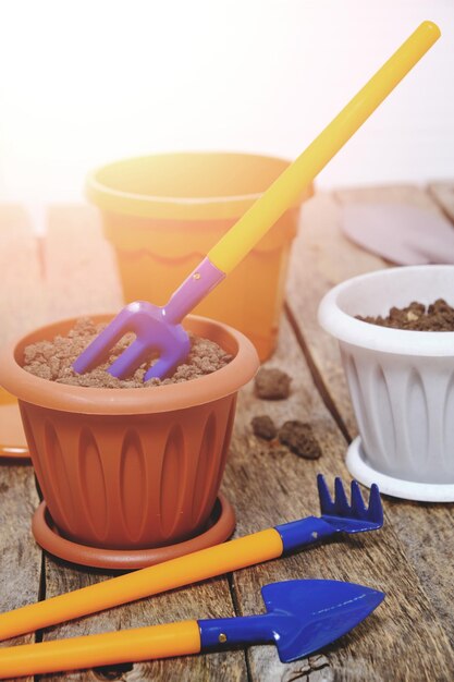 Bloempotten en decoratief tuingereedschap op een houten ondergrond in fel zonlicht zetten