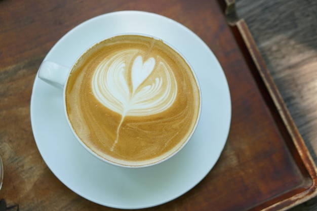 Bloemvormige warme koffie op een houten tafel geplaatst