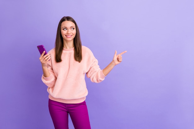 Blogger dame houdt telefoon punt vinger lege ruimte van paarse achtergrond