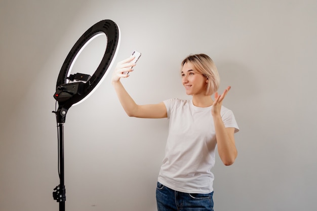 blogger girl zendt live uit via een smartphone onder een ringlamp