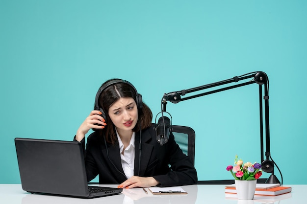 Blogger journalist brunette cute girl in black blazer recording speech on camera trying to listen