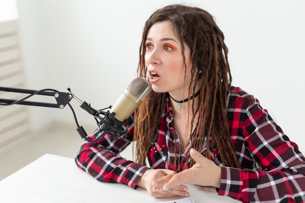 Blogger, conduttore radiofonico e concetto di persone - espressiva ragazza dj moderna con i dreadlocks che lavorano presso il