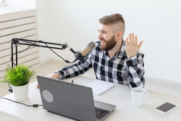 Blogger, streamer and people concept - Funny young man DJ working on the radio