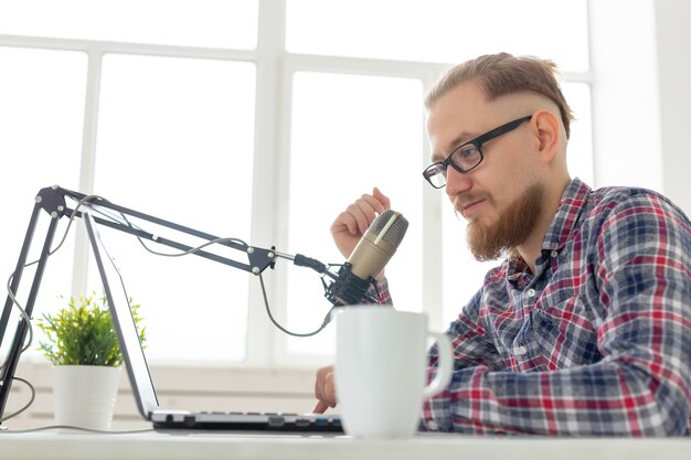 Blogger, streamer and people concept - Funny young man DJ working on the radio