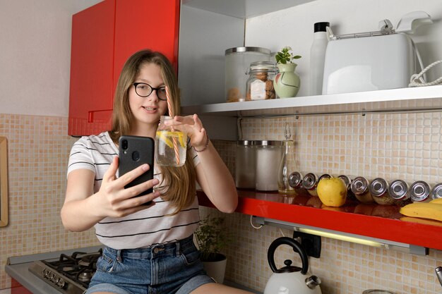 Photo blogger talking to a phone doing a live on social media showing a drink sitting in the kitchen