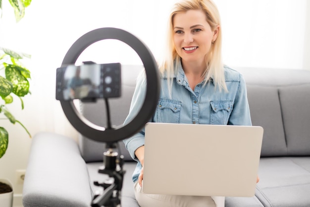 blogger woman records video with round lamp.