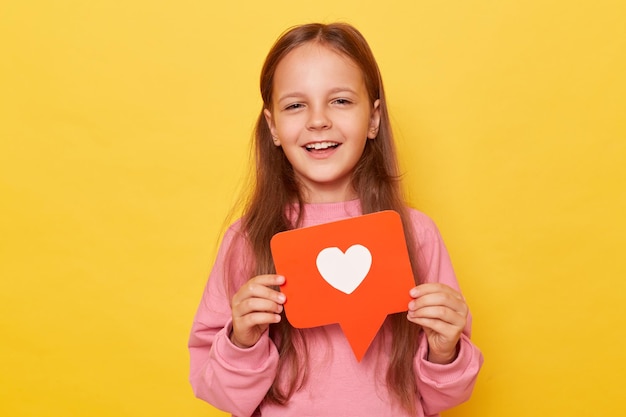 Photo blogging icon like button viral blog digital love share content smiling little girl wearing pink sweatshirt posing isolated over yellow background