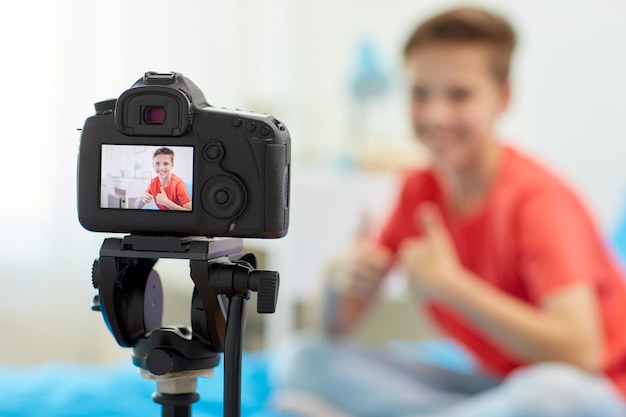 Blogging technology and people concept camera recording video of happy smiling blogger boy showing thumbs up at home