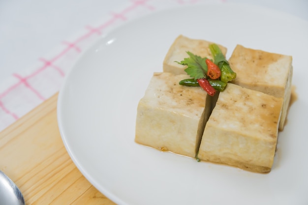 Blok van Tofu en snijplank met chili en gember