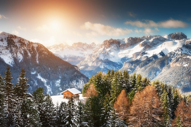 Blokhuis in de winterbergen bij zonsondergang. Skigebied in de Dolomieten Alpen. Val di Fassa, Italië. Prachtig winterlandschap