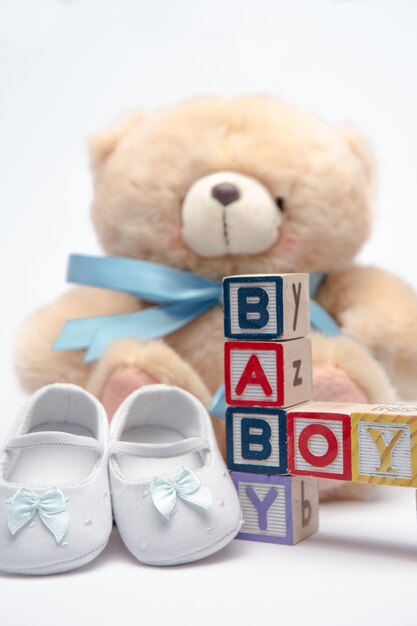 Blokken die babyjongen met teddy en babyschoenen spellen