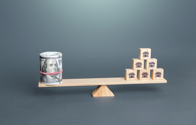 Blokken met symbolen van zakelijke winkels en geld dollars op weegschaal franchising waardering waarde