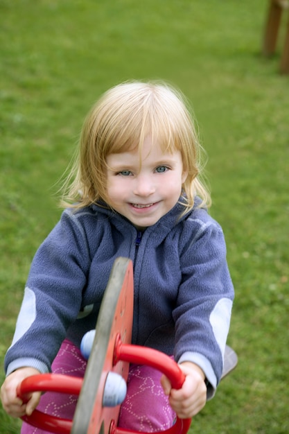 Blond adorable little girl playing playground