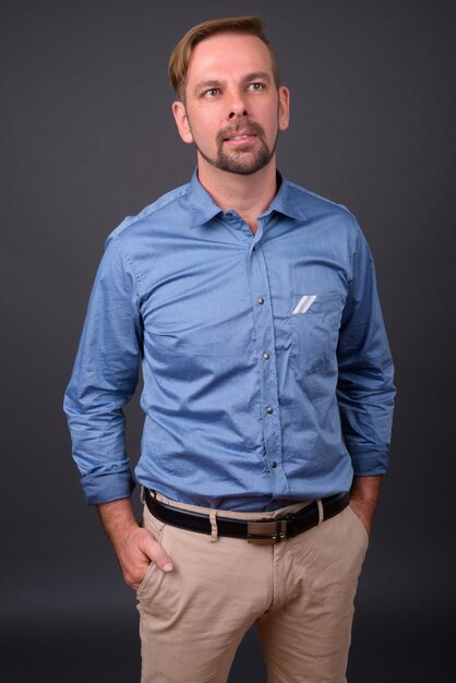 Photo blond bearded businessman with goatee against gray wall