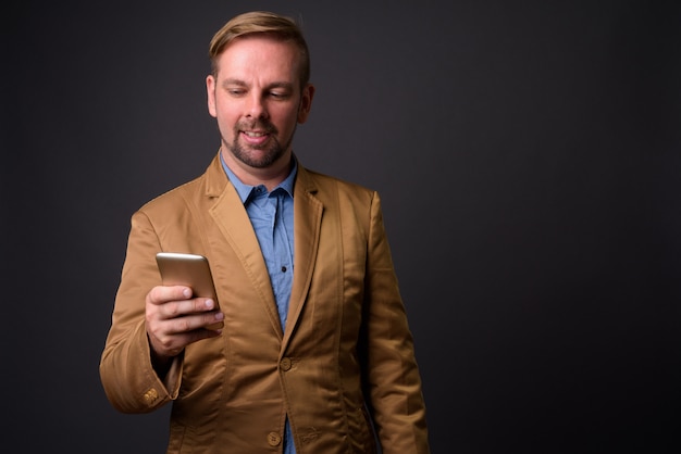 Blond bearded businessman with goatee against gray wall