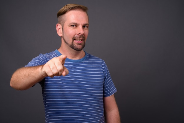 Photo blond bearded man with goatee against gray wall