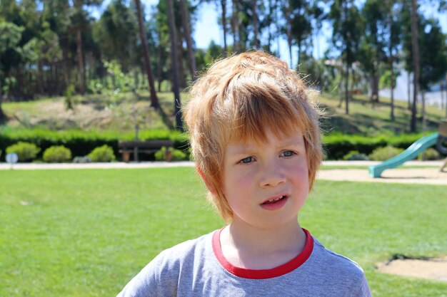 The blond boy looks into the distance with interest thoughtful six-year-old boy