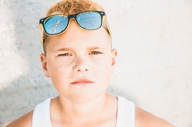 Blond boy in a white T-shirt with sunglasses on his head. close-up portrait